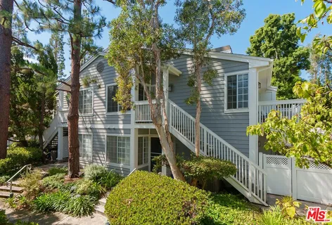a view of a house with brick walls and flower plants