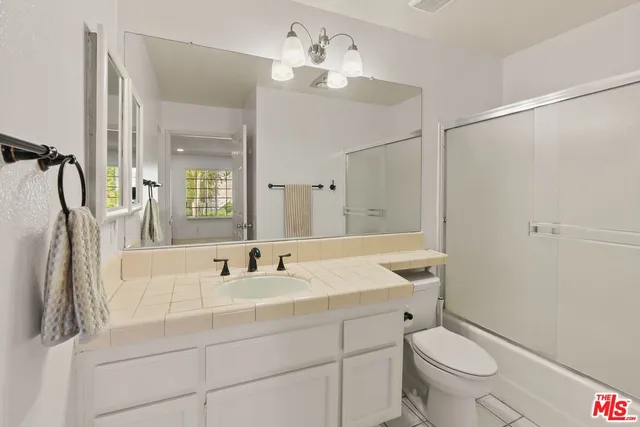 a bathroom with a sink toilet a mirror and shower