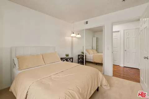 a bedroom with a bed and a large mirror