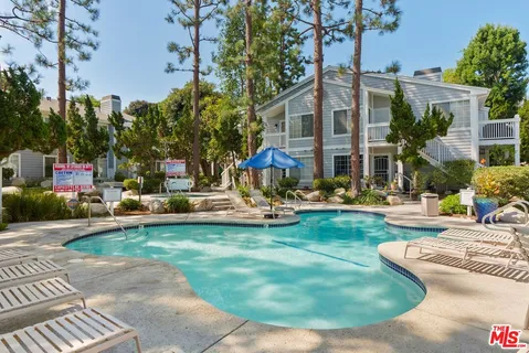 a view of a house with swimming pool and sitting area