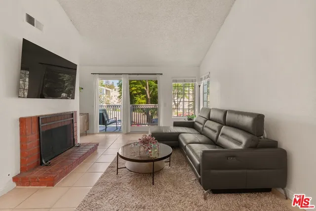 a living room with furniture a flat screen tv and a fireplace