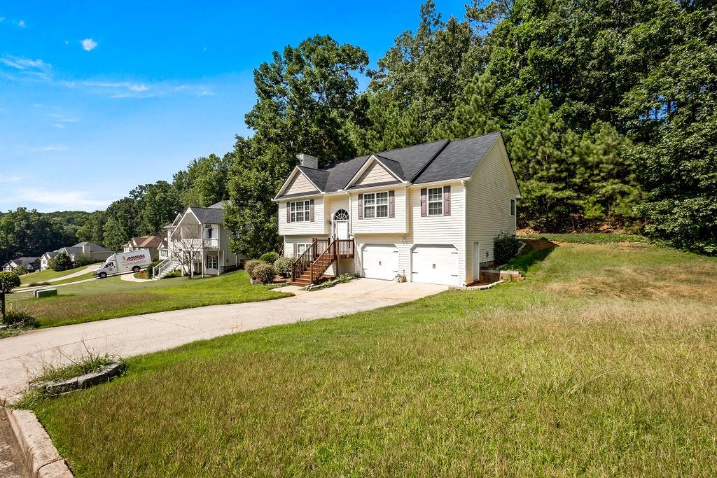 a view of a house with a big yard and large trees