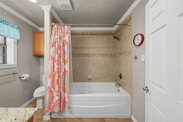 a bathroom with a shower curtain and a window