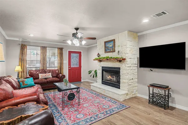 a living room with furniture a flat screen tv and a fireplace