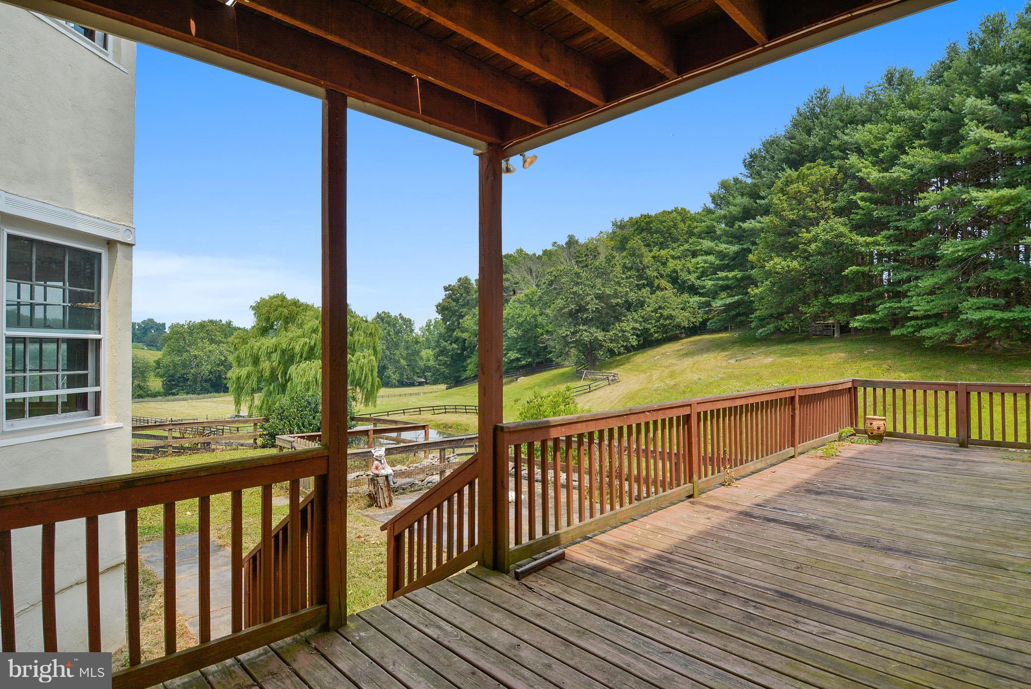 20852 St Louis Road Middleburg, VA 20117 - Photo 7 of 29 a view of a balcony with wooden floor next to a yard