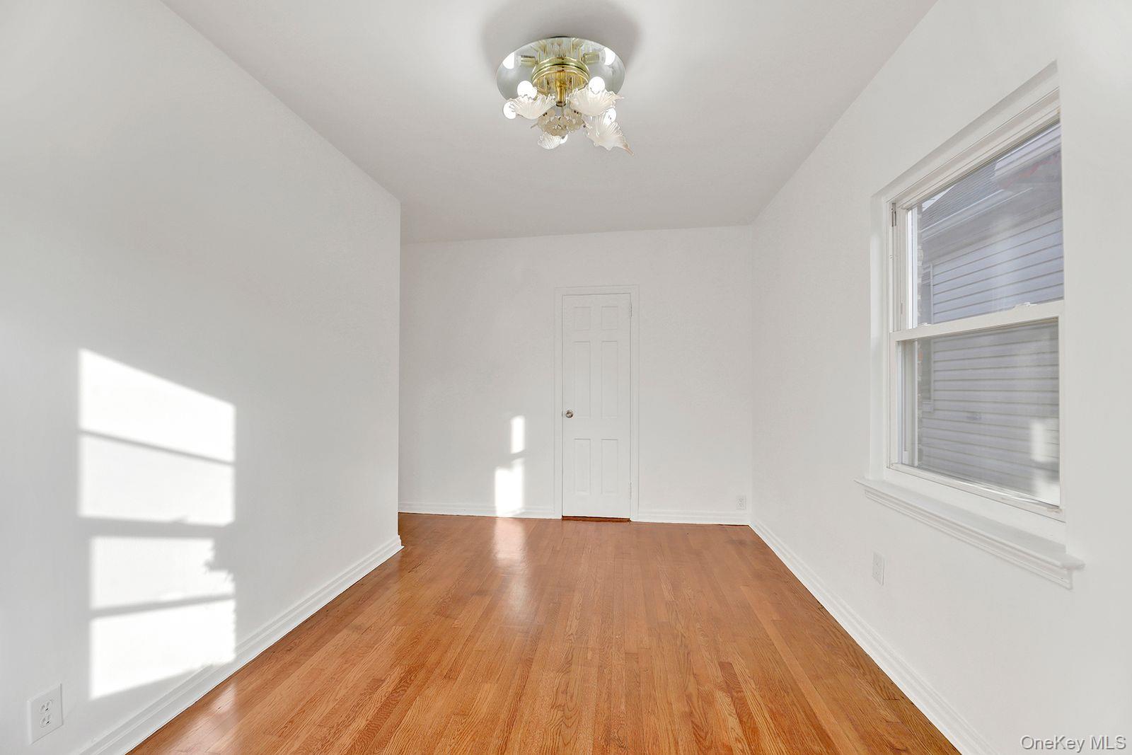102-12 62nd Road Queens, NY 11375 - Photo 12 of 27 a view of empty room with wooden floor and fan