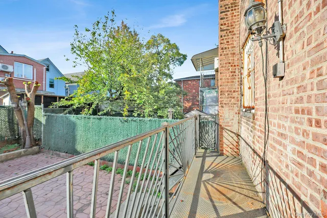 a view of balcony with a yard and wooden fence