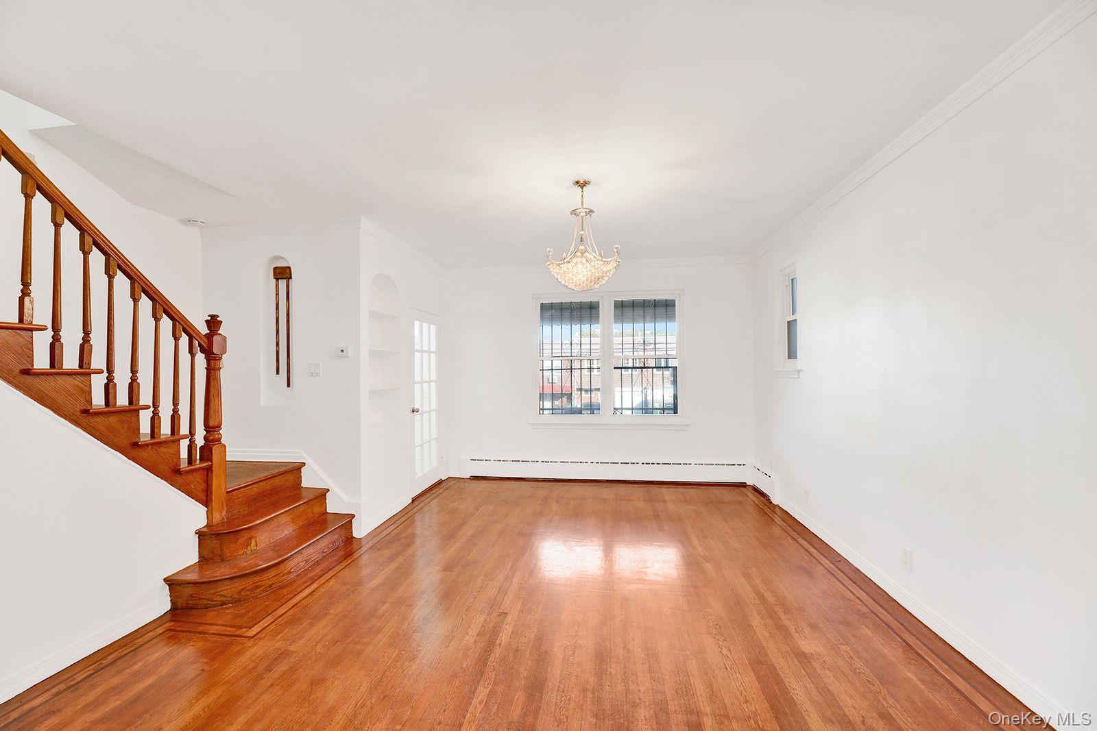 102-12 62nd Road Queens, NY 11375 - Photo 3 of 27 a view of an empty room with wooden floor and a window