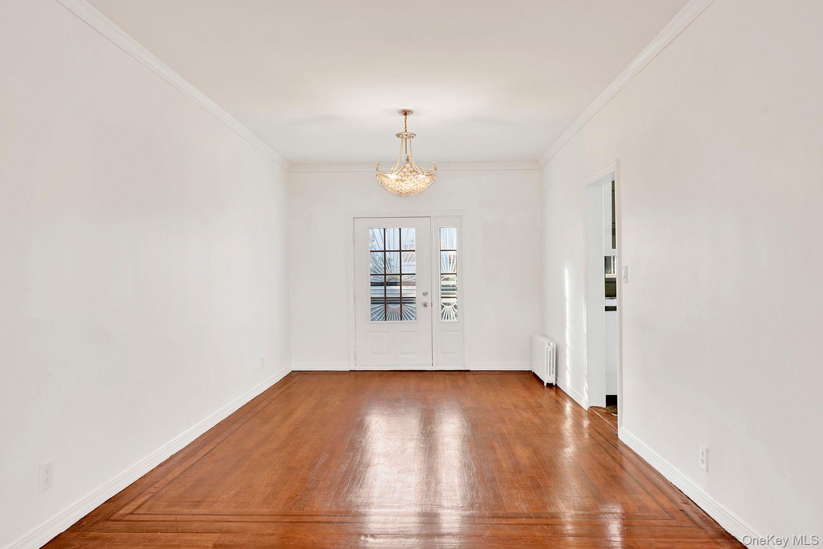 102-12 62nd Road Queens, NY 11375 - Photo 7 of 27 an empty room with wooden floor fan and windows