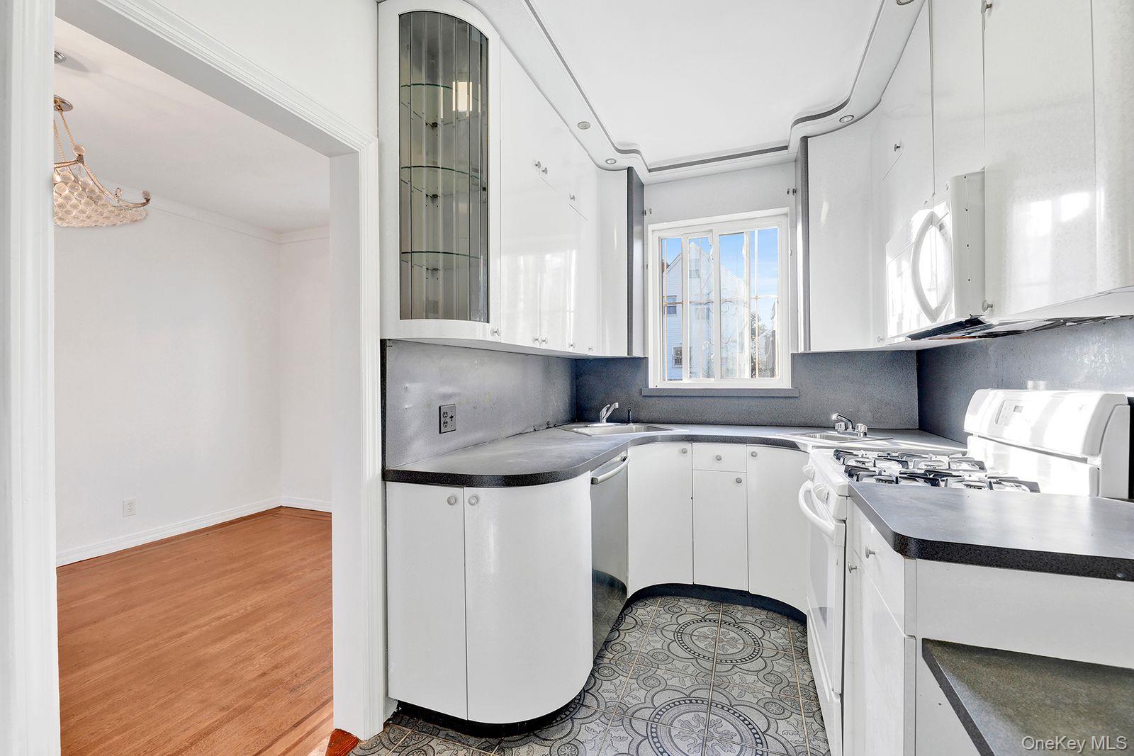 102-12 62nd Road Queens, NY 11375 - Photo 8 of 27 a kitchen with a stove a sink and a refrigerator