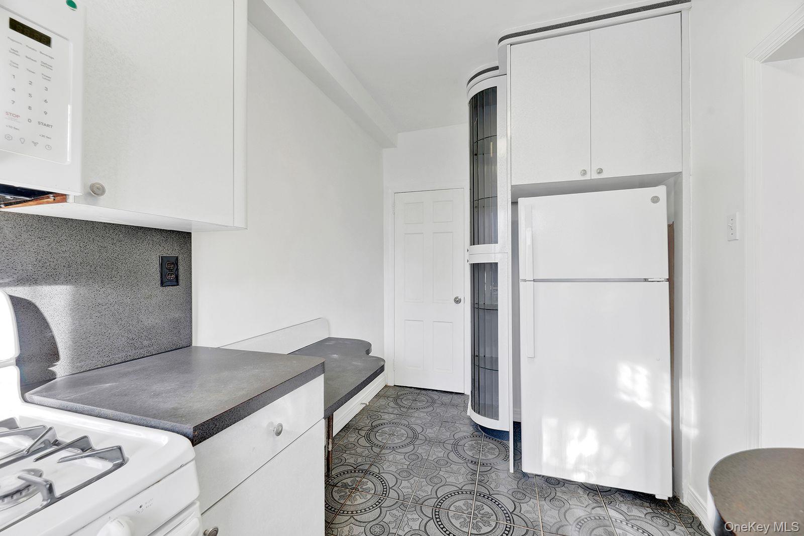 102-12 62nd Road Queens, NY 11375 - Photo 10 of 27 a kitchen with a refrigerator and a stove