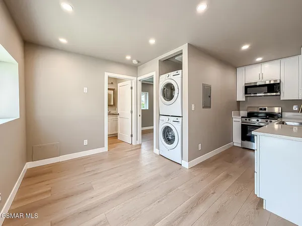 a view of kitchen with stainless steel appliances granite countertop a refrigerator and a stove top oven