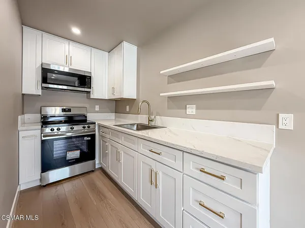 a kitchen with stainless steel appliances granite countertop a sink and a stove