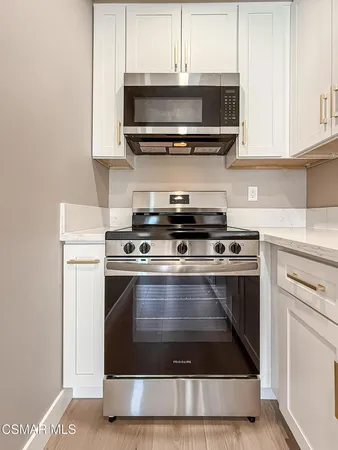 a stove top oven sitting inside of a kitchen