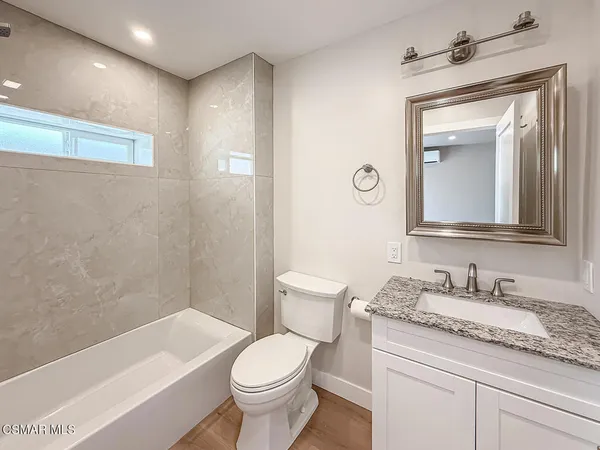 a bathroom with a granite countertop toilet a sink and bathtub