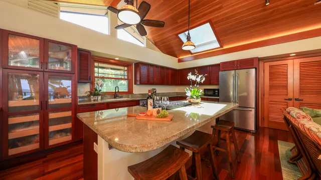 a kitchen with stainless steel appliances granite countertop table chairs and a wooden floor