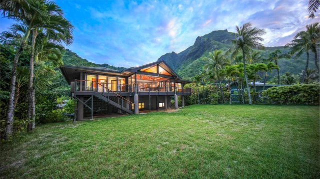 a view of a house with backyard and a tree