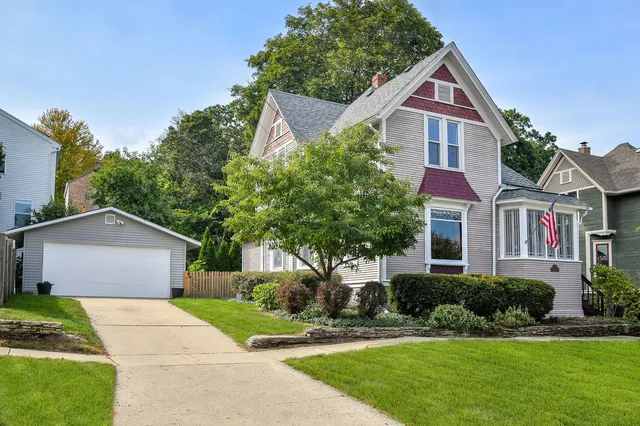 a front view of a house with a yard and trees