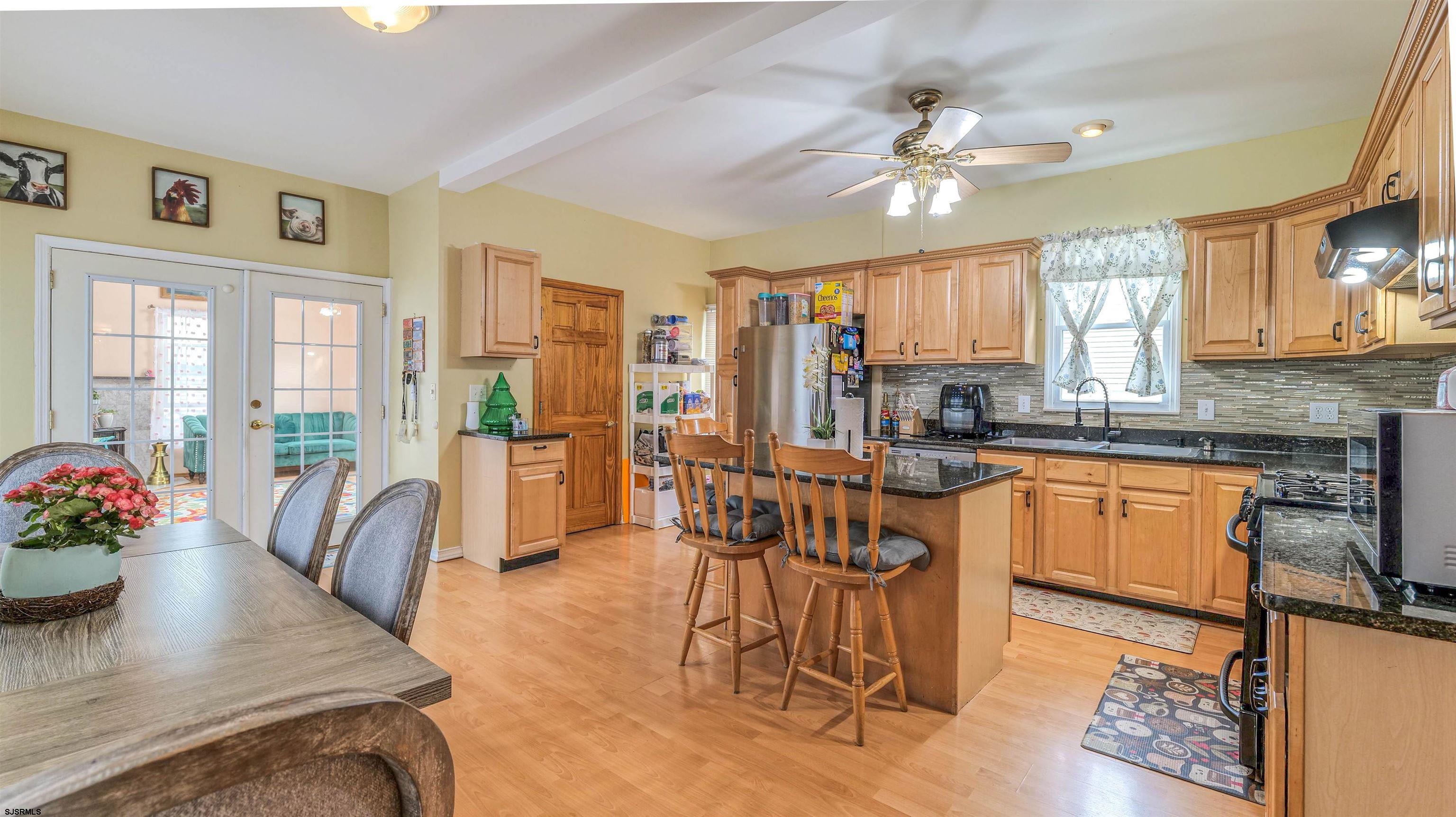 6015 Main Street Mays Landing, NJ 08330 - Photo 15 of 42 a kitchen with granite countertop a stove a sink a dining table and chairs
