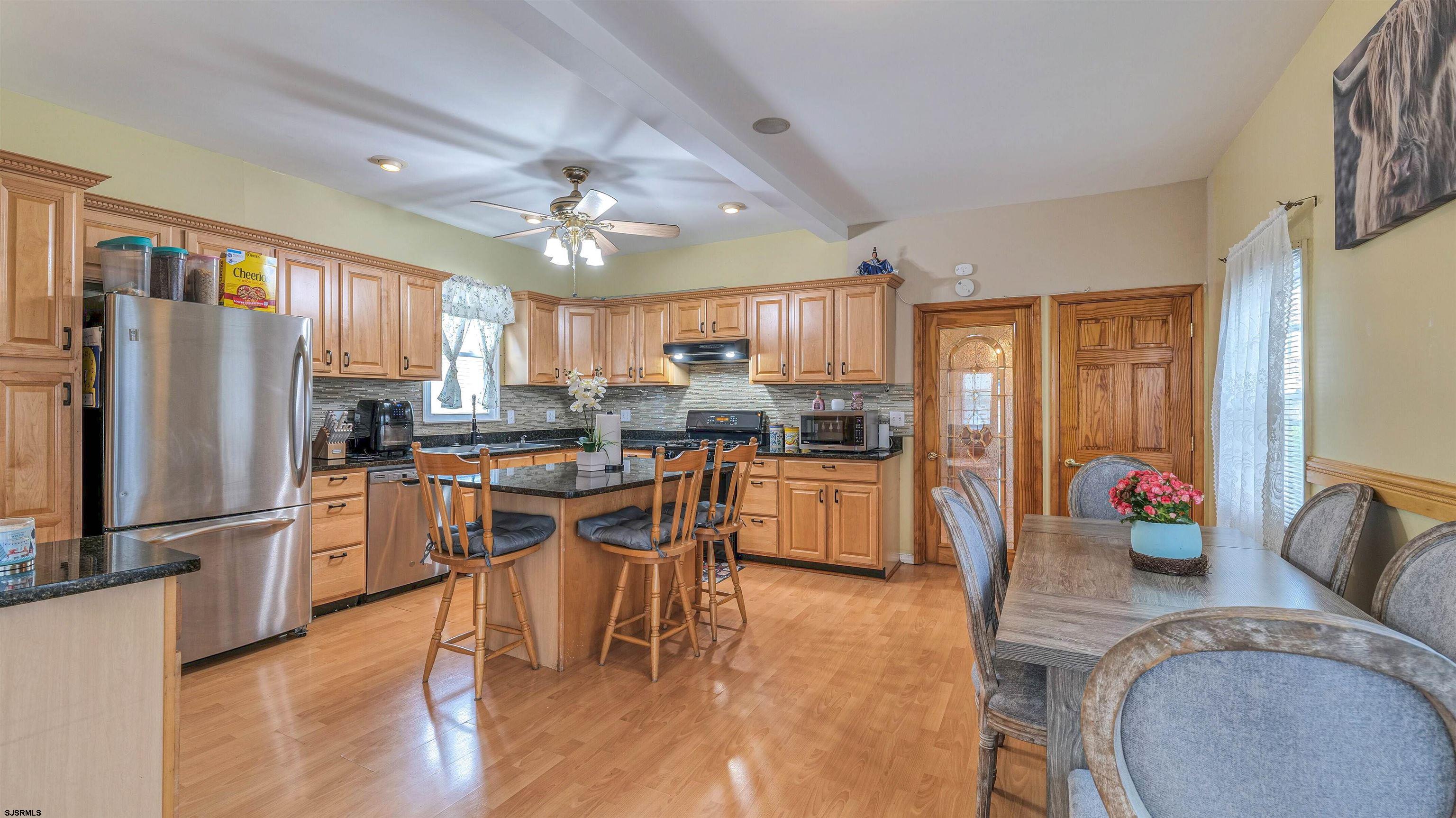 6015 Main Street Mays Landing, NJ 08330 - Photo 16 of 42 a kitchen with stainless steel appliances granite countertop a refrigerator a stove top oven a sink dishwasher and white cabinets with wooden floor