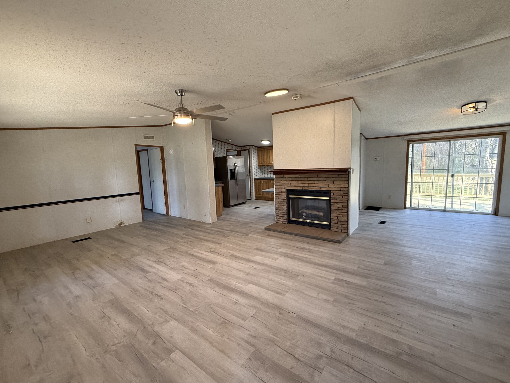 2421 Anes Station Road Lewisburg, TN 37091 - Photo 6 of 16 an empty room with wooden floor fireplace and windows