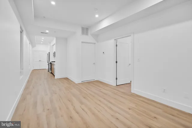 a view of empty room with wooden floor