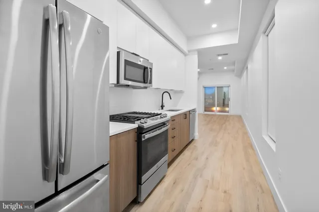 a large kitchen with a stove a sink and a refrigerator