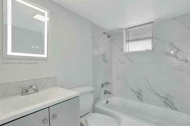 a bathroom with a sink toilet vanity and tub