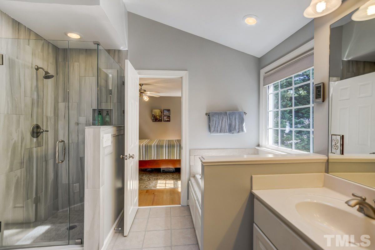 7934 Pine Timber Drive Raleigh, NC 27613 - Photo 11 of 22 a en suite bathroom with a sink a mirror and shower