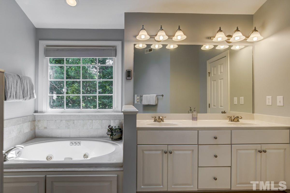 7934 Pine Timber Drive Raleigh, NC 27613 - Photo 12 of 22 a bathroom with a sink a large mirror and a bathtub