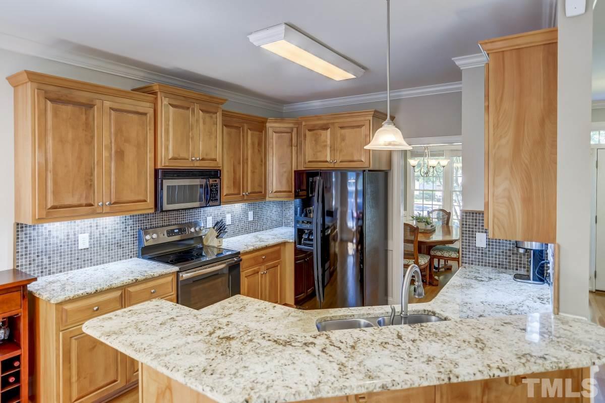 7934 Pine Timber Drive Raleigh, NC 27613 - Photo 7 of 22 a kitchen with stainless steel appliances granite countertop sink stove refrigerator and cabinets