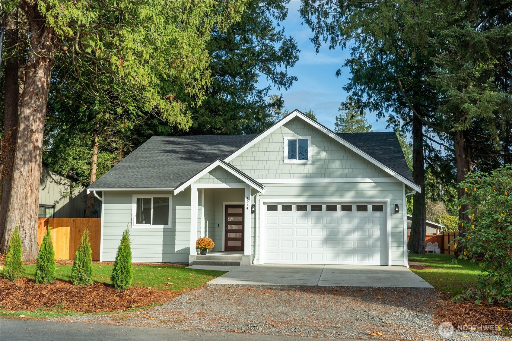 a view of a house with a yard and large tree