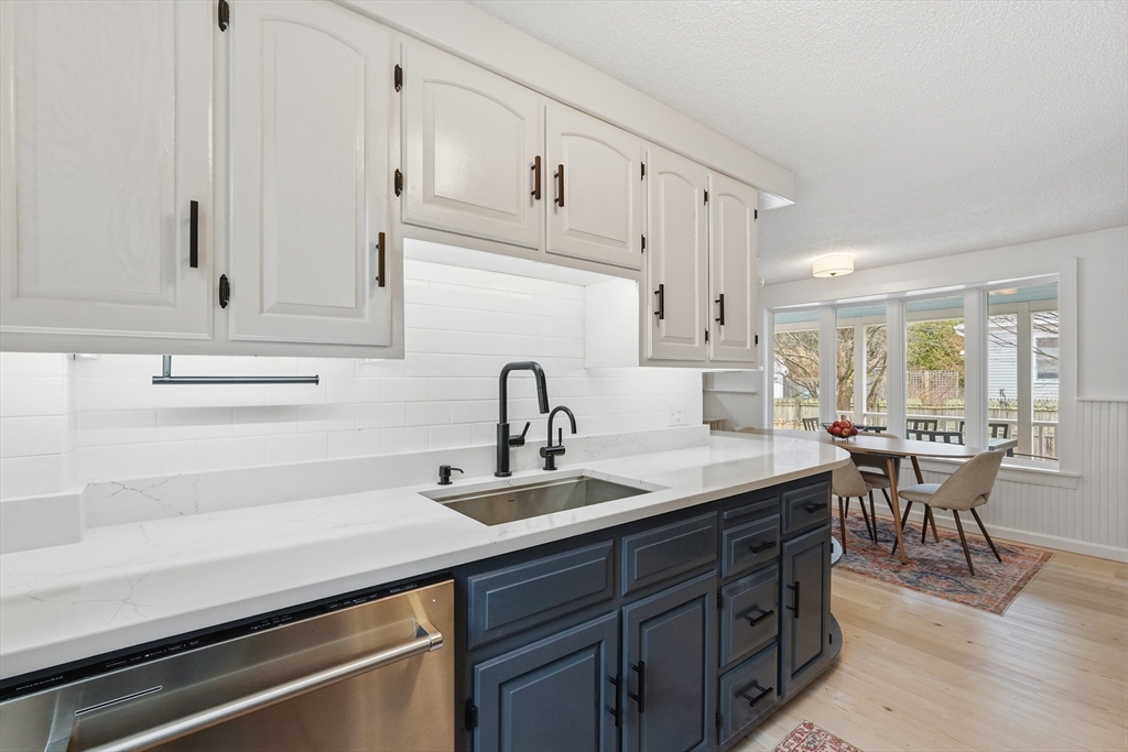 38 Front Street Northampton, MA 01053 - Photo 16 of 42 a kitchen with stainless steel appliances granite countertop a sink dishwasher and white cabinets with wooden floor