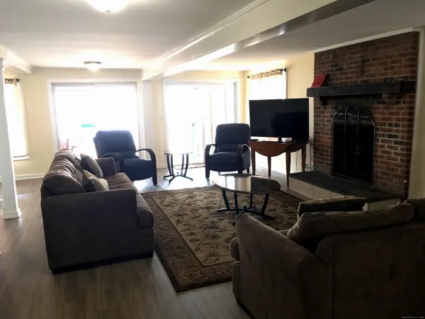 a view of a dining room with furniture a chandelier and wooden floor