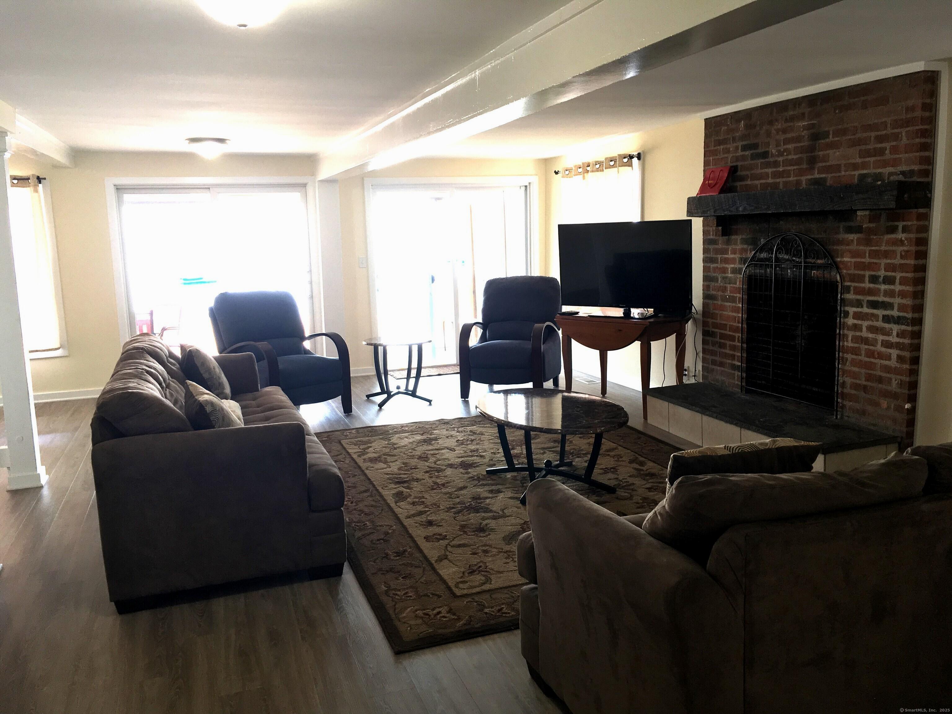 989 Fairfield Beach Road Fairfield, CT 06824 - Photo 11 of 27 a living room with furniture and a fireplace