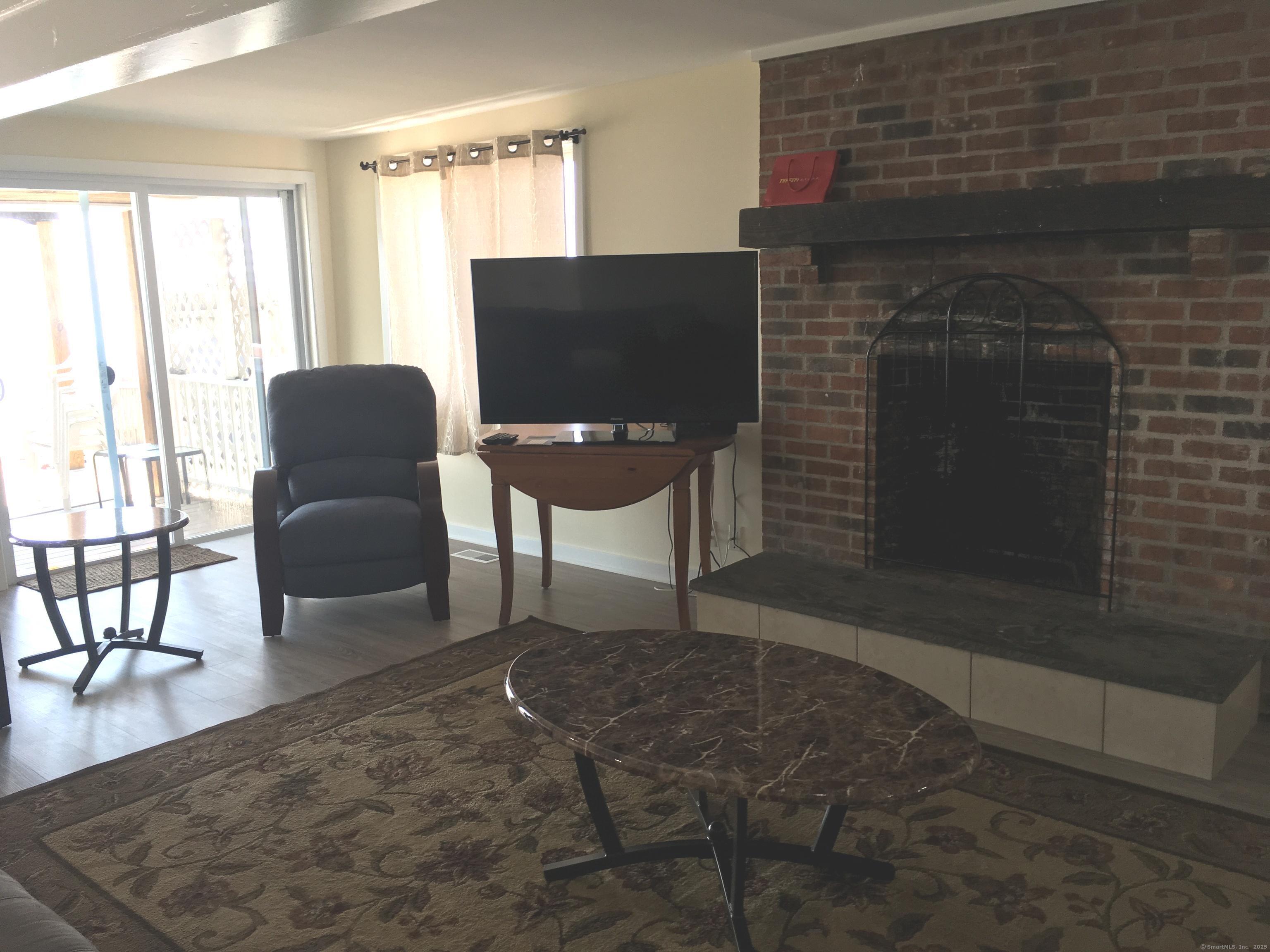 989 Fairfield Beach Road Fairfield, CT 06824 - Photo 13 of 27 a living room with furniture and a fireplace