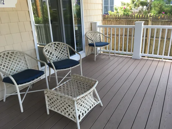 a view of balcony with wooden floor outdoor seating and yard in back