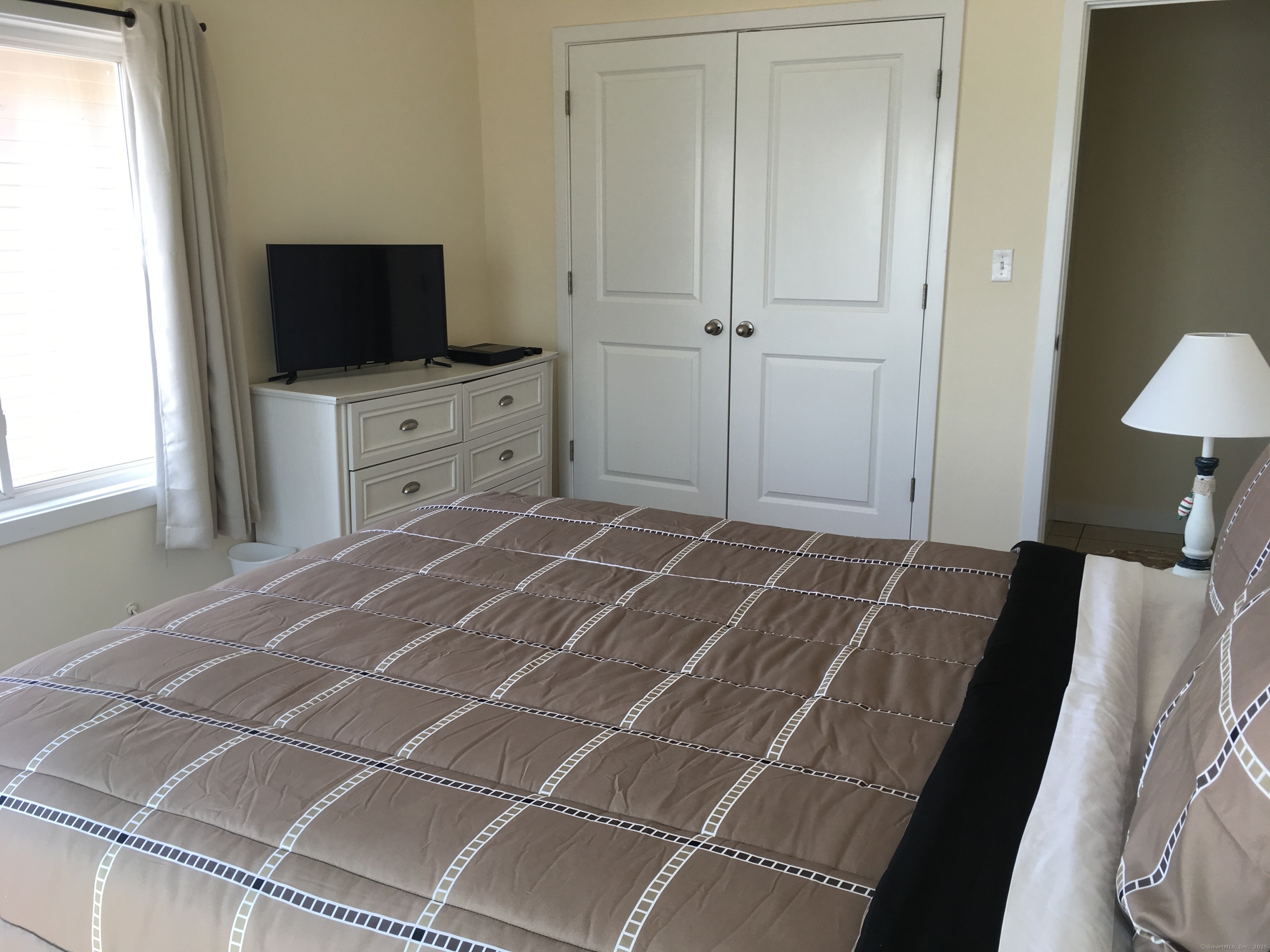 989 Fairfield Beach Road Fairfield, CT 06824 - Photo 22 of 27 a room with a bed and a flat screen tv