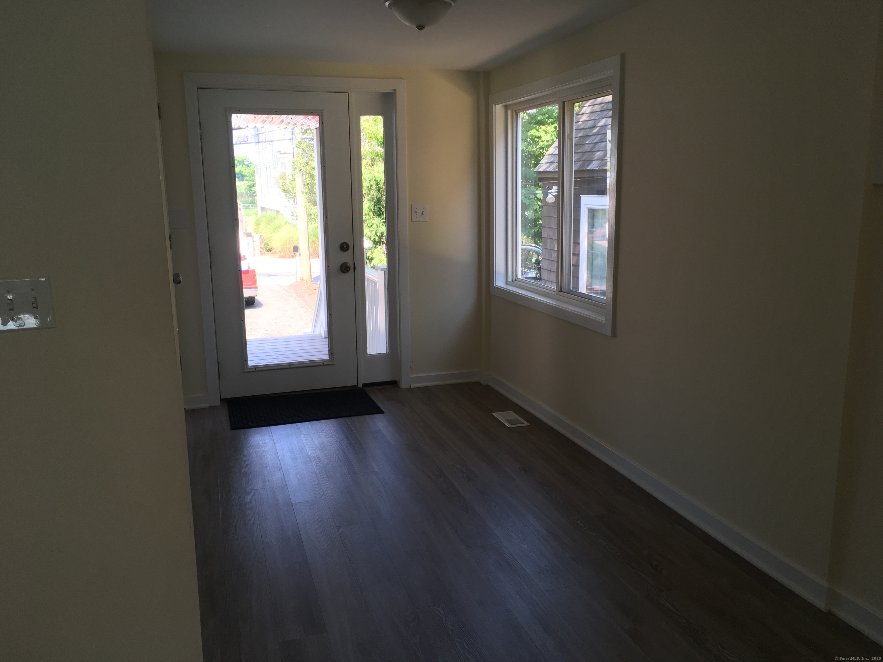 989 Fairfield Beach Road Fairfield, CT 06824 - Photo 3 of 27 an empty room with wooden floor and windows