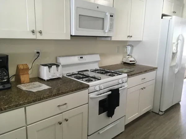 a white stove top oven sitting inside of a kitchen