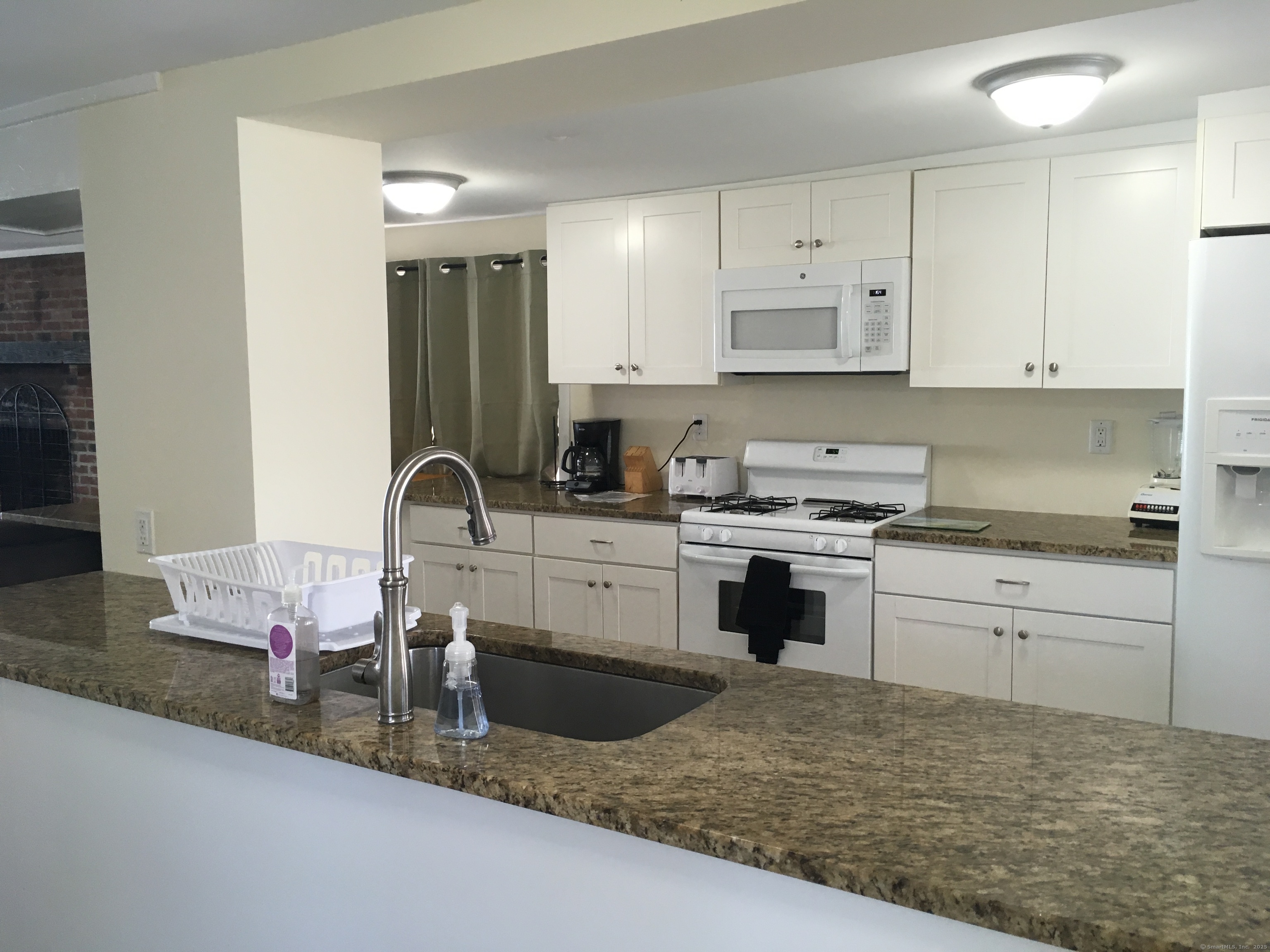 989 Fairfield Beach Road Fairfield, CT 06824 - Photo 5 of 27 a kitchen with granite countertop a sink stove and cabinets