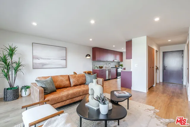 a living room with furniture and a dining table with wooden floor
