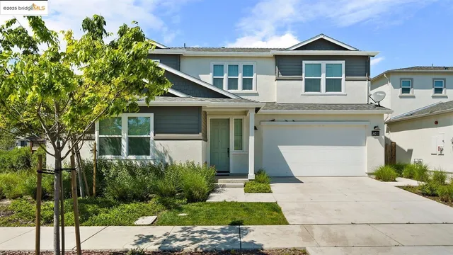 a front view of a house with a yard and potted plants