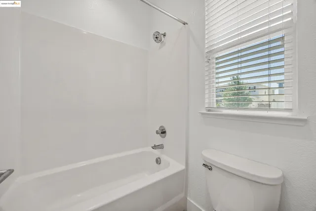 a bathroom with a bathtub a window and a shower
