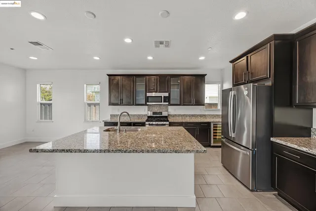 a kitchen with granite countertop a refrigerator and a sink