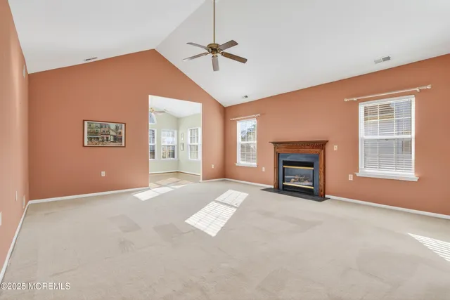 an empty room with windows and fireplace