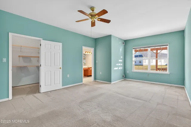 an empty room with closet and fan