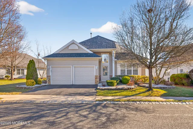 a view of a house with a yard and large tree