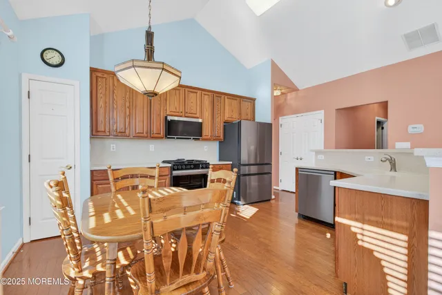 a kitchen with stainless steel appliances a dining table chairs and granite counter tops