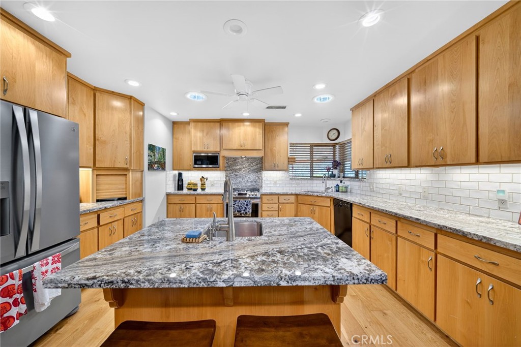 4872 N Arcade Fresno, CA 93704 - Photo 11 of 75 a kitchen with stainless steel appliances granite countertop wooden cabinets sink and granite counter tops